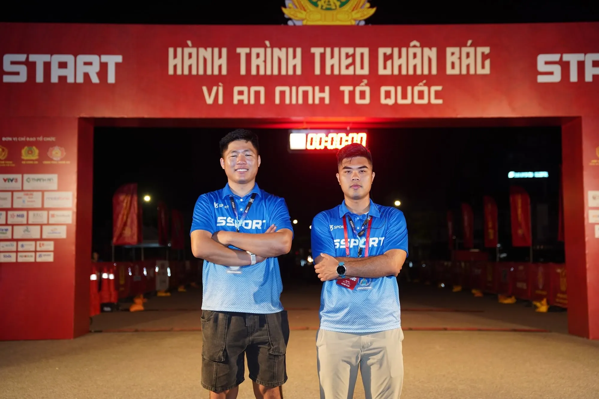 Two 5SPORT staff members under the start arch before the gun