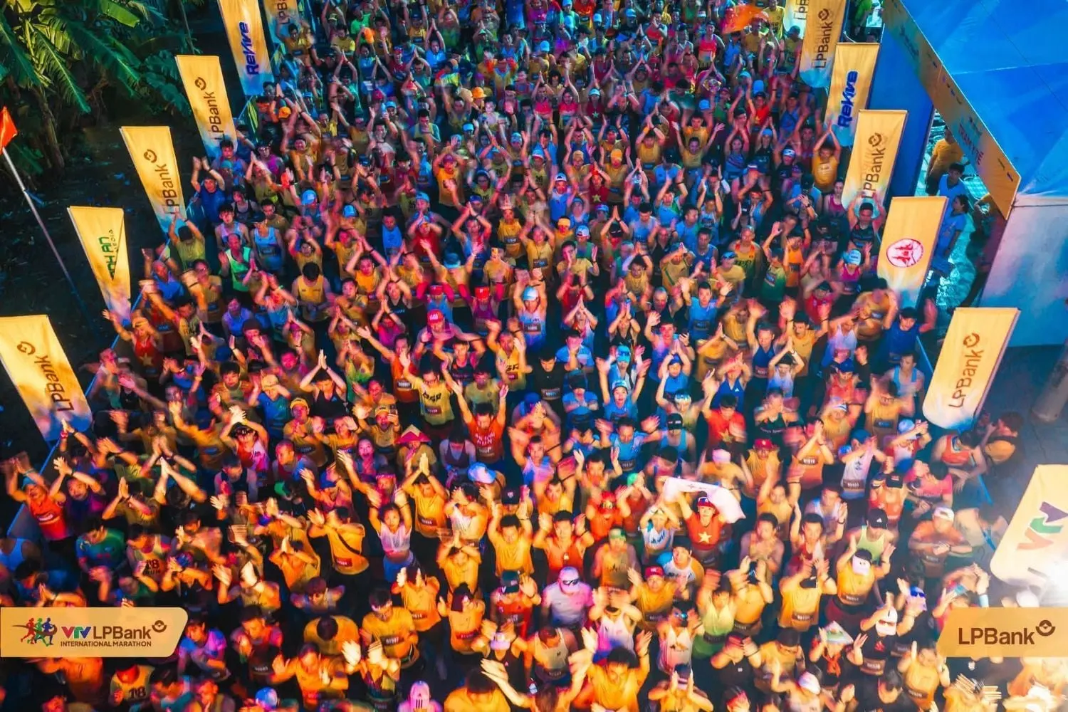 Thousands of runners raising their hands in the start area