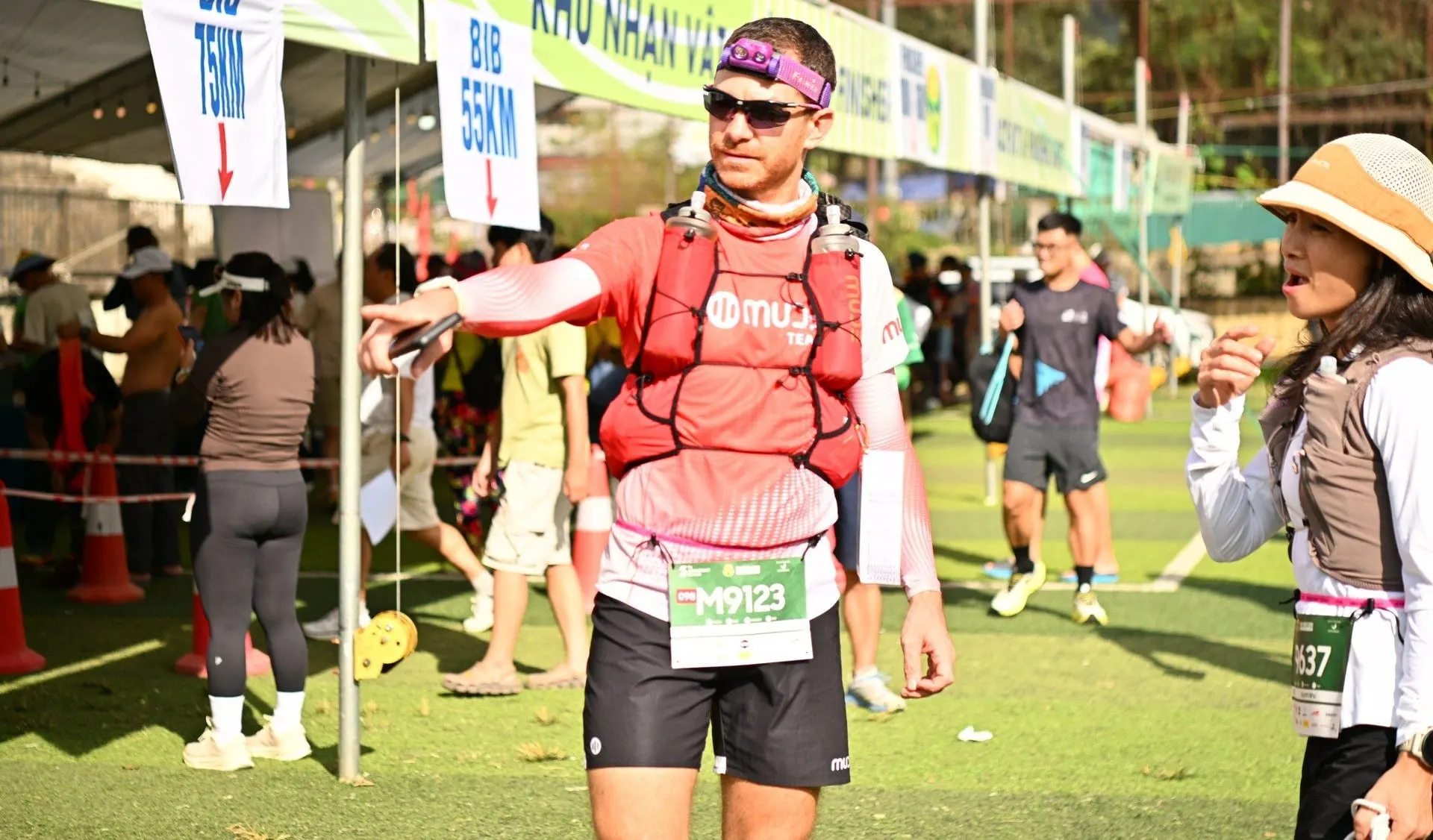 A participant wearing a bib leaves the race-kit desk