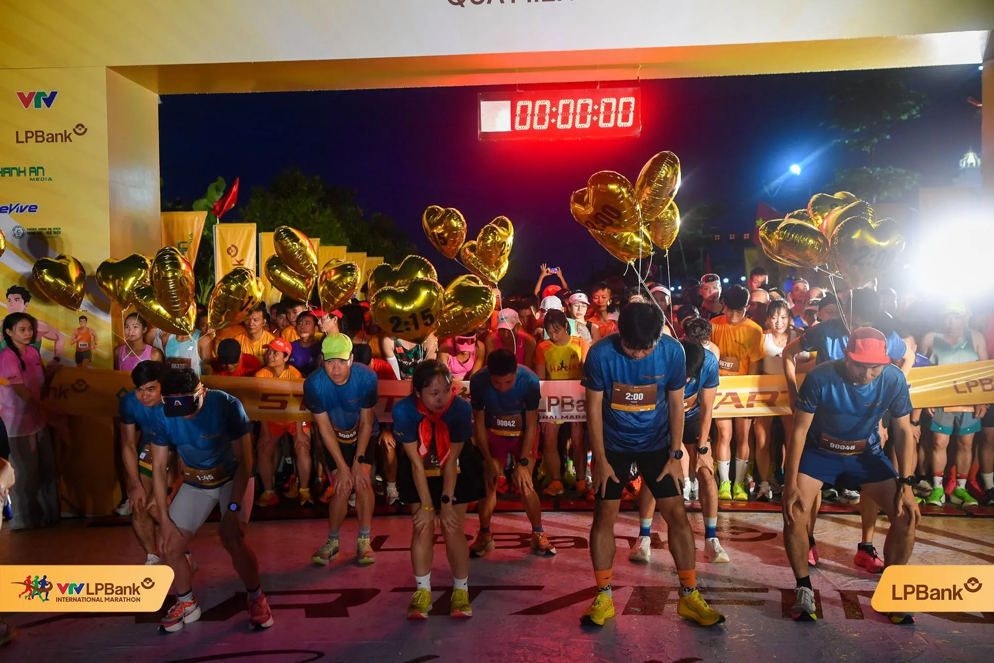 Pacers in blue holding gold time balloons under the arch, clock at 00:00:00
