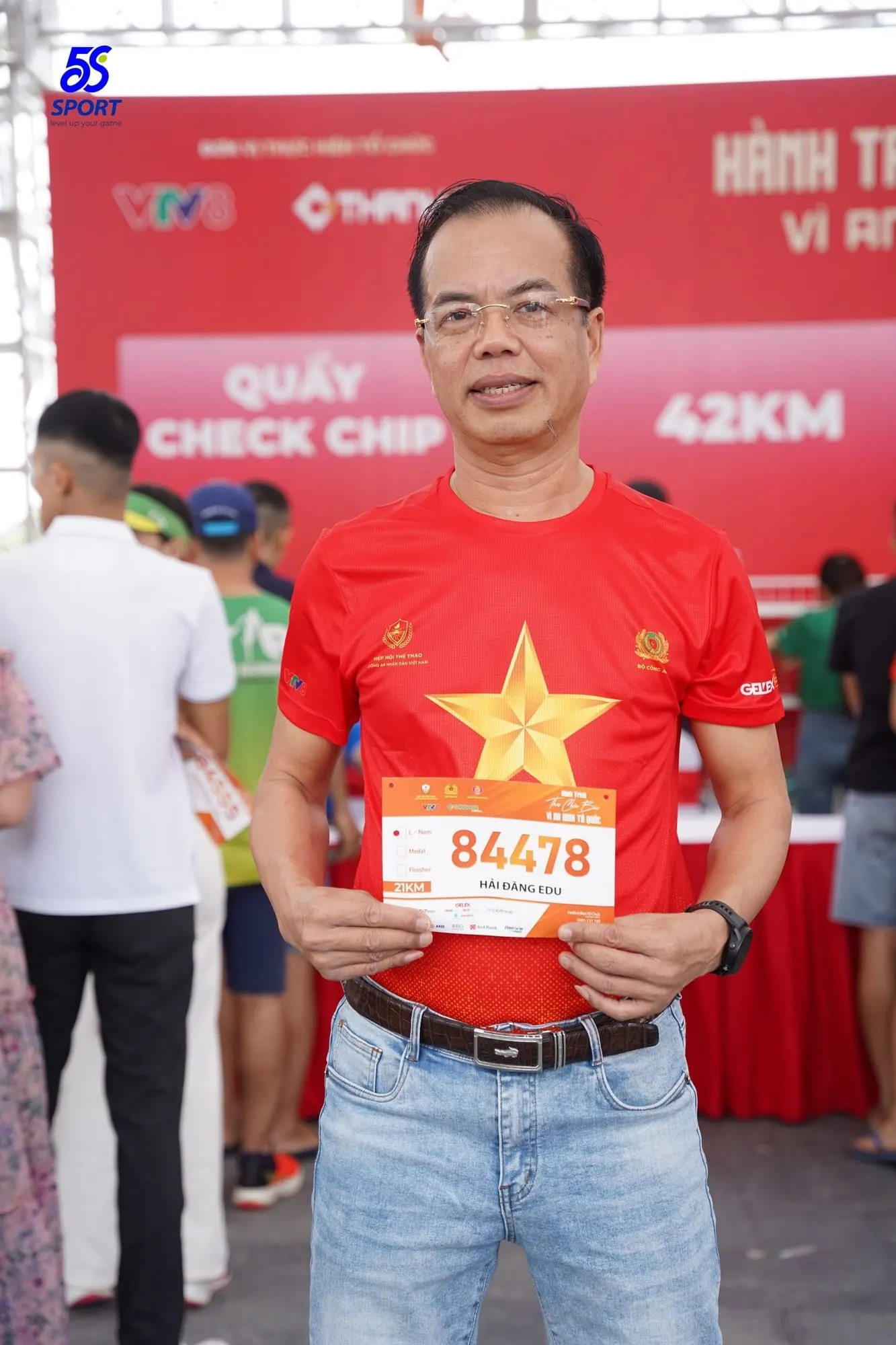 Vận động viên giơ số BIB tại quầy kiểm tra chip cự ly 42 km