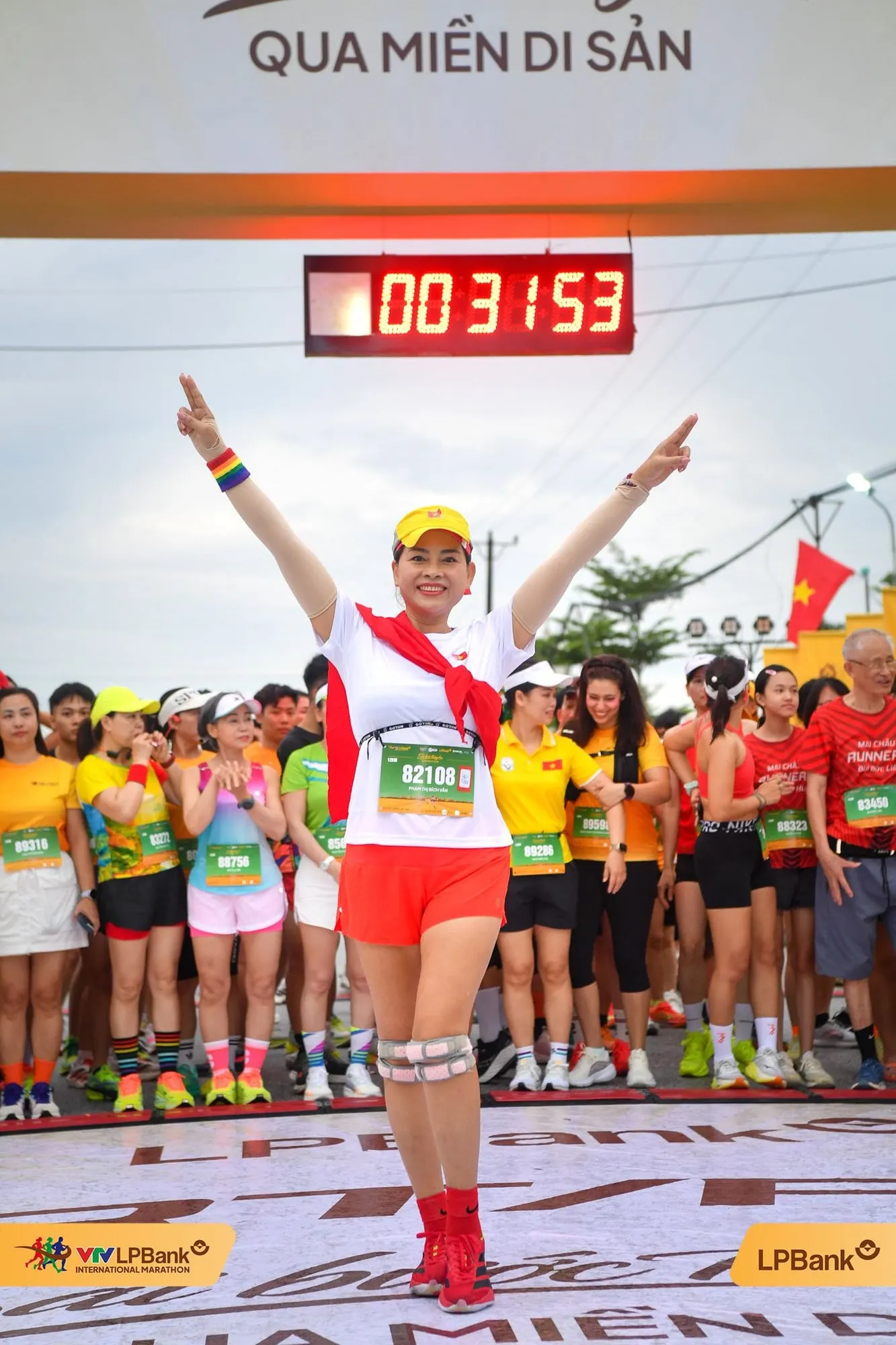 Nữ vận động viên giơ hai tay dưới đồng hồ 00:31:53